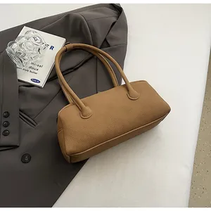 Detail of tan pebble leather bowling bag with smooth metal zipper and twin handles