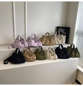 Close-up of textured nylon handbags in various colors on minimalist white display steps