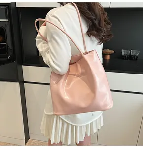 Detail of pink glossy leather tote bag showing smooth texture and silver magnetic closure