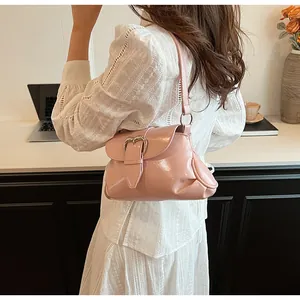 Détail du sac à bandoulière en similicuir rose avec une boucle en métal en forme de cœur