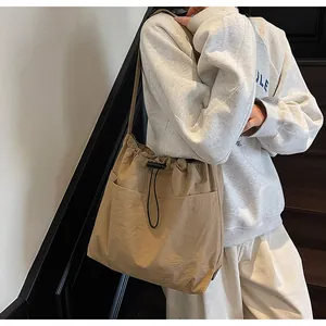 Détail d'un sac seau en nylon kaki durable avec fermeture à cordon et de grandes poches