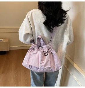 Detail of lavender drawstring tote bag showing side view on model with adjustable strap