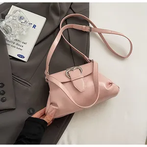 Vue détaillée du sac à main plissé rose avec boucle coeur argentée sur fond gris doux