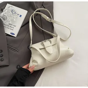 Détail du sac en cuir crème avec boucle coeur argentée et plis latéraux élégants