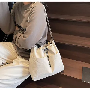 Détail du sac bandoulière en nylon blanc cassé avec cordon et texture plissée
