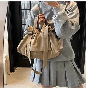 Detail view of khaki crossbody bag featuring drawstring closure and adjustable strap