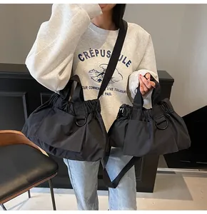 Detail of black drawstring nylon tote bag with pleated texture and adjustable strap