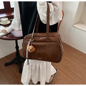 Close-up of vintage brown leather tote bag featuring a rich logo and stylish silk scarf