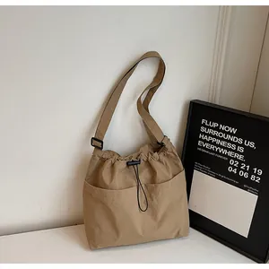 Détail du sac seau en nylon kaki avec bandoulière réglable et fermeture à cordon