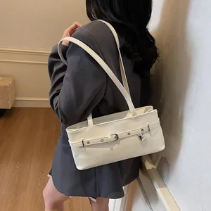 Sac sous le bras beige brillant minimaliste avec pendentif cœur argenté et boucle