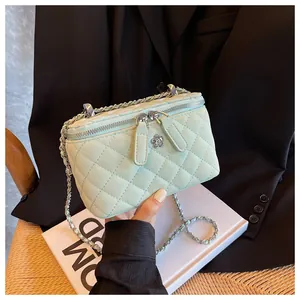 Dettaglio borsa trapuntata verde menta con catena argento e logo a fiore