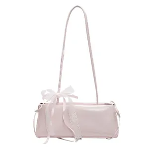 Chic pink shoulder bag with elegant white lace bow detail and minimalist long strap