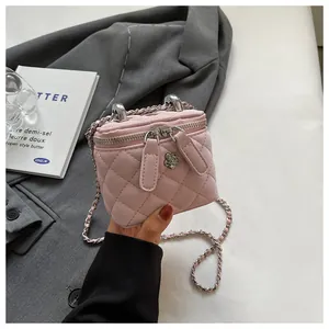 Close-up of pink quilted vanity bag with silver flower clasp and dual metal handles