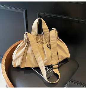 Detailed view of the khaki pleated nylon tote bag with adjustable shoulder strap and texture