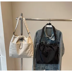 Détail de sacs seaux en nylon durable beige et noir avec fermeture à cordon