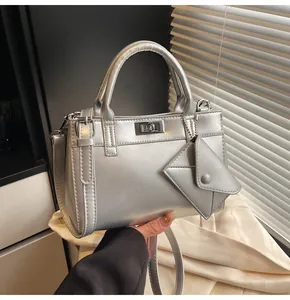 Detailed macro view of the silver metallic handbag with matching envelope charm and turn-lock