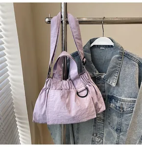 Detail of light purple pleated tote bag featuring textured fabric and a black D-ring hook