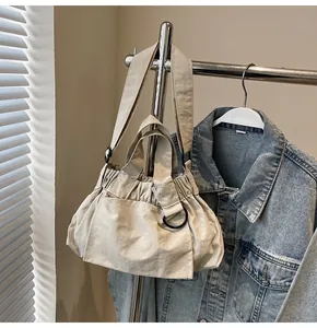 Detail shot of beige ruched tote bag with adjustable shoulder strap and d-ring hardware