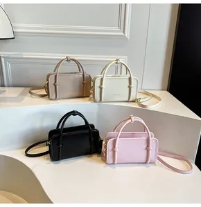 Détail de quatre sacs à main en similicuir coloré avec ferrures dorées et bandoulière