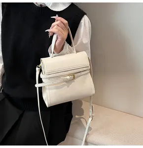 Détail du sac à main en cuir blanc crème avec bandoulière réglable et boucle décorative