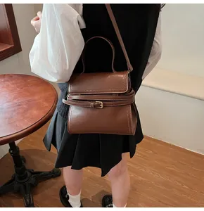 Vue détaillée d'un sac en cuir marron avec boucle dorée et bandoulière réglable