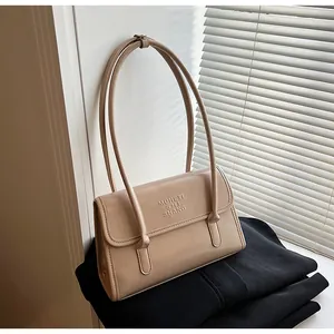 Detailed view of the beige leather shoulder bag with logo embossing and double thin straps