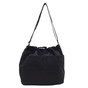 Grand sac à bandoulière en nylon noir avec cordon de serrage et poche frontale pratique