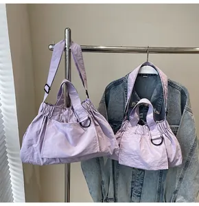 Lavender nylon tote bag set with drawstring detail and black metal hardware on denim jacket