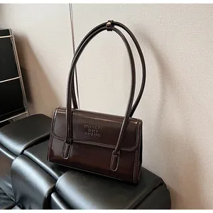 Detail shot of a dark brown glossy shoulder bag featuring embossed MUHETI SHI SHANG logo