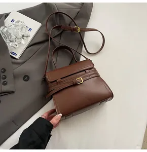 Détail du sac à main en cuir caramel avec boucle dorée et bandoulière amovible réglable