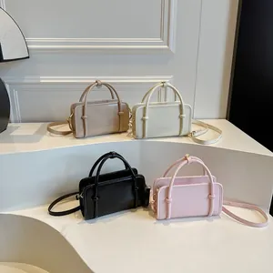 Sacs à bandoulière minimalistes carrés en crème, beige, rose et noir en vitrine