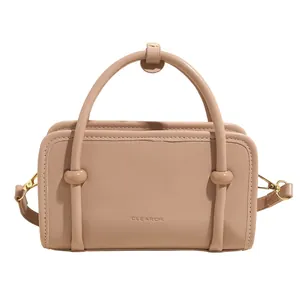 Sac à main rectangulaire en cuir rose avec poignée ronde et bandoulière réglable