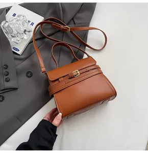 Détail du sac carré marron caramel avec lanière en cuir décorative et boucle en métal