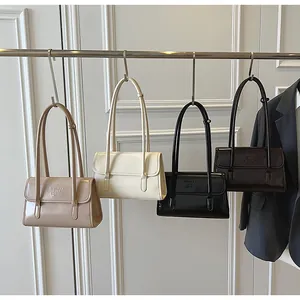 Detail view of stylish leather shoulder bags in beige, white, black, and brown colors