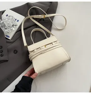 Détail d'un sac à main blanc cassé avec boucle de ceinture décorative et garniture dorée