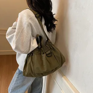 Army green nylon tote bag with pleated design and wide shoulder strap for women