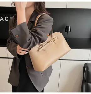 Detail view of khaki leather shoulder bag featuring metal eyelet strap and large capacity