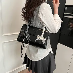 Chic black flap shoulder bag with ribbon charms and pearl pendant for women