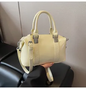 Detail view of cream Boston handbag with smooth synthetic leather and silver metal hardware
