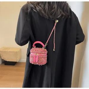 Détail du mini sac boîte en tweed rose avec bandoulière chaîne dorée et double zip