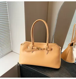 Detail view of stylish light brown tote bag with metal buckle on dark wooden surface