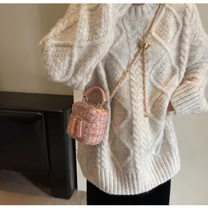 Détail du mini sac en tweed rose montrant la chaîne dorée et la boule métallique