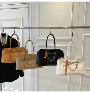 Detail view of large shoulder bags with gold chains and heart charms in four colors