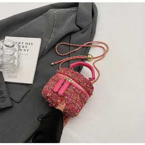 Détail de mini sac en tweed rose avec bandoulière chaîne dorée sur veste grise