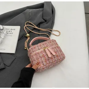 Détail du sac à main en tweed rose avec bandoulière chaîne et boule métallique
