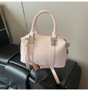 Detail of light pink leather Boston bag with silver hardware and adjustable strap