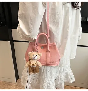 Bolso cuadrado pequeño rosa con textura de lichi y un tierno colgante de peluche