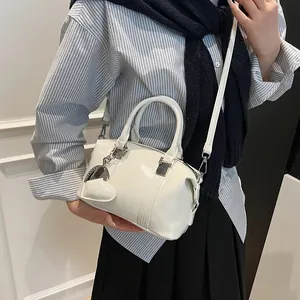 Glossy white Boston handbag with heart charm and shoulder strap for women