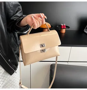 Detailed shot of cream beige leather crossbody bag with silver twist locks and strap