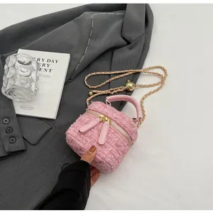 Détail du sac cylindre en tweed rose avec chaîne à boule dorée et double fermeture éclair
